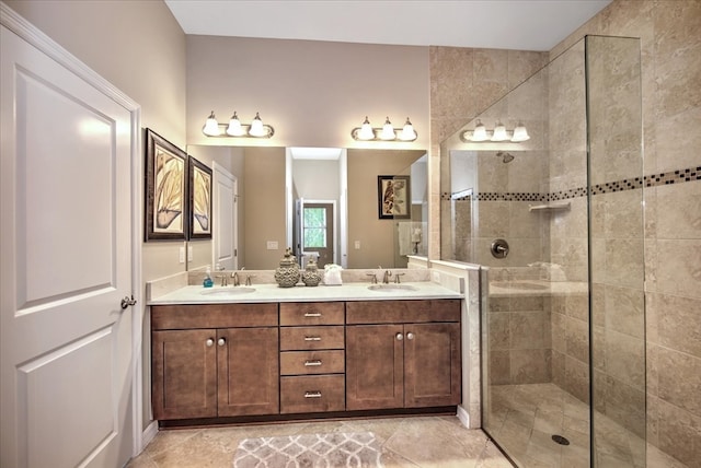 bathroom with tile patterned flooring, vanity, and a tile shower