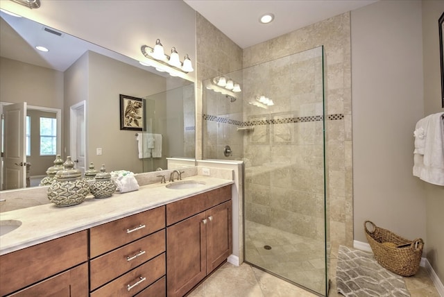 bathroom with tiled shower, tile patterned floors, and vanity