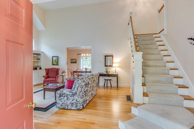 20 Crestview Cir, Barnstable, MA 02632 - living area with light wood finished floors, a high ceiling, stairs, baseboards, and a chandelier