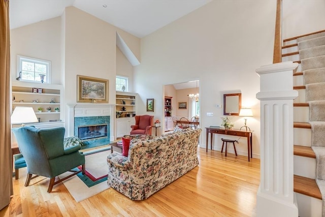 20 Crestview Cir, Barnstable, MA 02632 - living room featuring high vaulted ceiling, light wood-type flooring, stairway, a high end fireplace, and a chandelier
