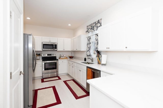 kitchen featuring white cabinets, appliances with stainless steel finishes, and sink