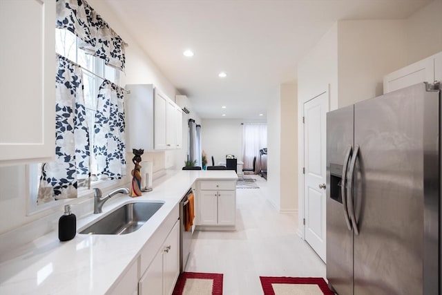 kitchen with white cabinets, sink, appliances with stainless steel finishes, kitchen peninsula, and a wall unit AC