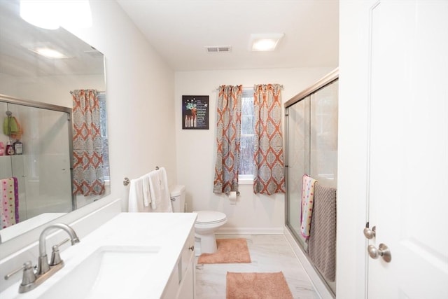 bathroom featuring vanity, toilet, and an enclosed shower