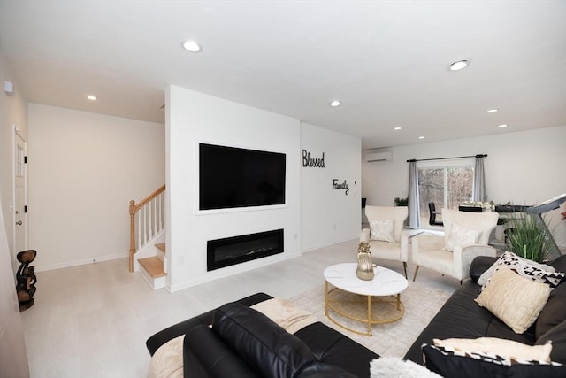 living room featuring an AC wall unit and light wood-type flooring