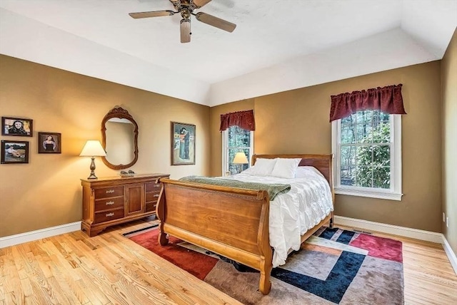 bedroom with light wood finished floors, baseboards, ceiling fan, and lofted ceiling