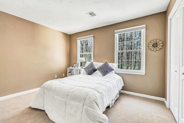 bedroom with baseboards, carpet flooring, and a closet