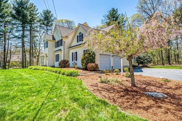 view of front of property featuring asphalt driveway and a front yard