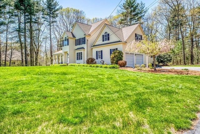 traditional-style house featuring a front lawn, concrete driveway, and an attached garage