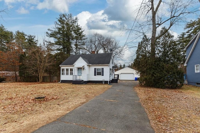 view of front facade featuring a garage and an outbuilding