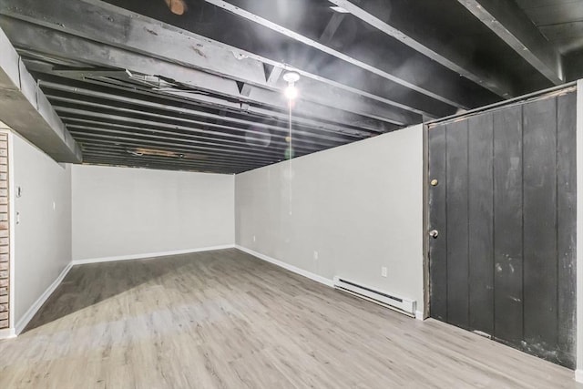 basement with hardwood / wood-style flooring and baseboard heating