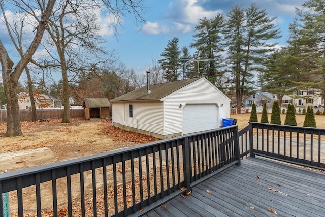 wooden deck featuring a garage and a storage unit