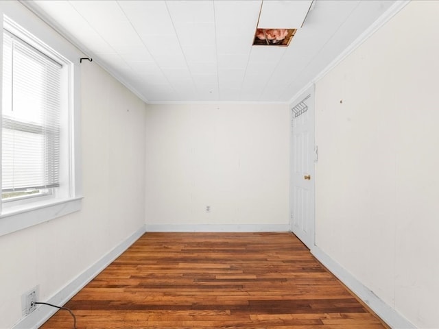 spare room with hardwood / wood-style flooring and crown molding