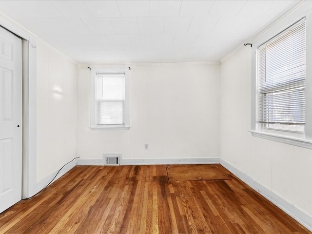 empty room featuring hardwood / wood-style floors and ornamental molding