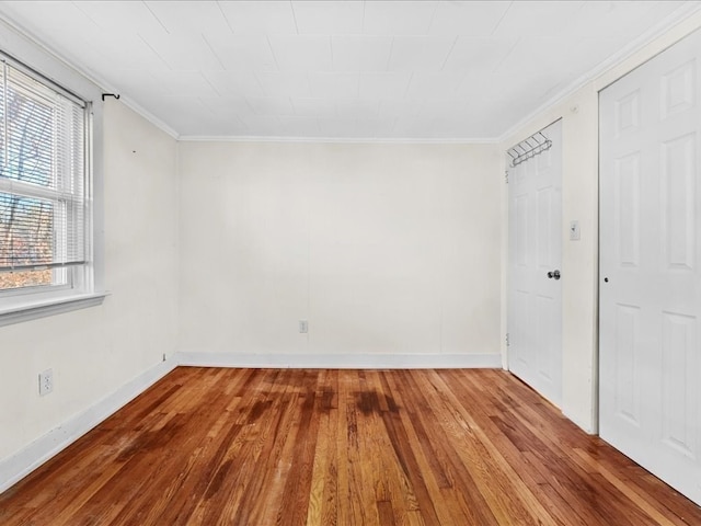 spare room featuring wood-type flooring and ornamental molding