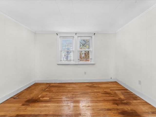 empty room featuring wood-type flooring and ornamental molding