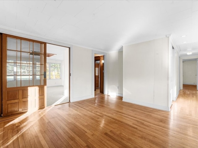 spare room featuring light hardwood / wood-style flooring and crown molding