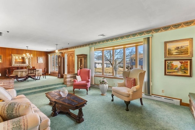 living room with a chandelier, baseboard heating, wood walls, and carpet