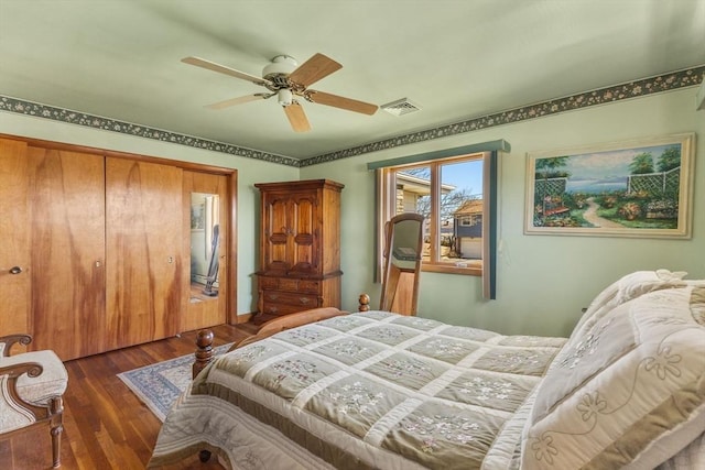 bedroom featuring ceiling fan, visible vents, a closet, and wood finished floors