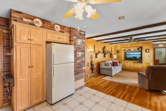 kitchen featuring radiator, brick wall, open floor plan, freestanding refrigerator, and a ceiling fan