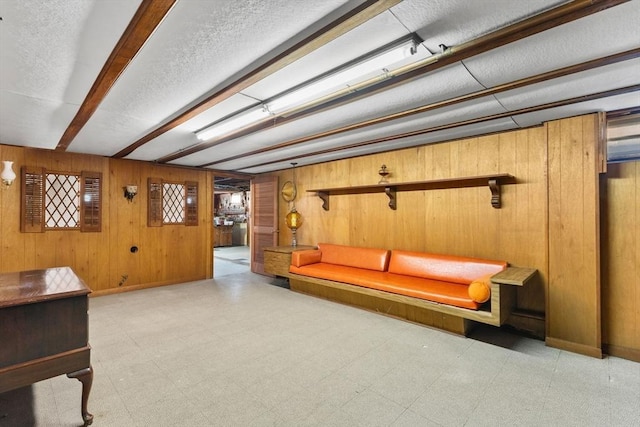 living room featuring tile patterned floors, wooden walls, and baseboards