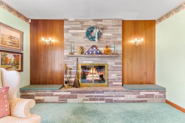 interior space with a stone fireplace, wood walls, and carpet