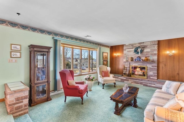 carpeted living area featuring visible vents, wooden walls, baseboard heating, and a fireplace