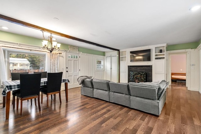 living room with beamed ceiling, a chandelier, dark hardwood / wood-style flooring, and built in shelves