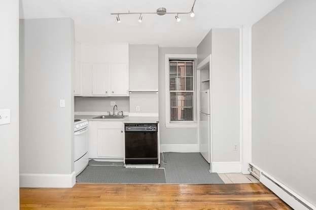 kitchen with white cabinets, sink, white appliances, wood-type flooring, and baseboard heating