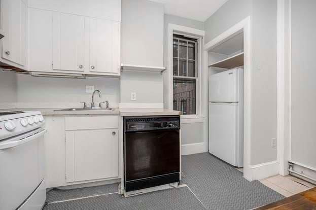 kitchen with white appliances, white cabinets, and sink