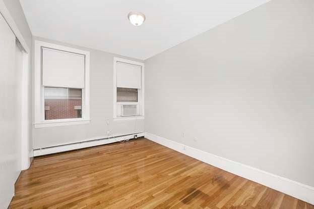 unfurnished room featuring cooling unit, a baseboard radiator, and hardwood / wood-style flooring