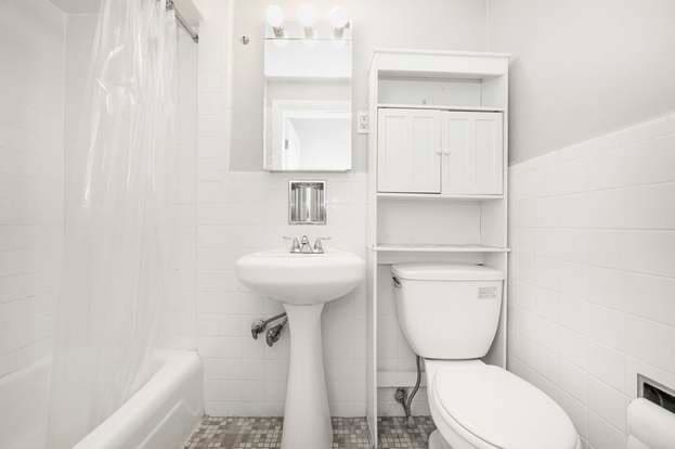 bathroom with shower / tub combo with curtain, tile walls, and toilet