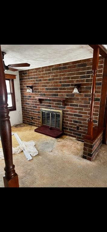 unfurnished living room with light carpet and a brick fireplace