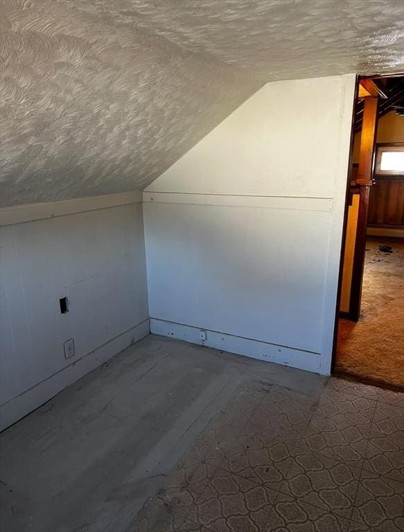 bonus room featuring a textured ceiling and vaulted ceiling