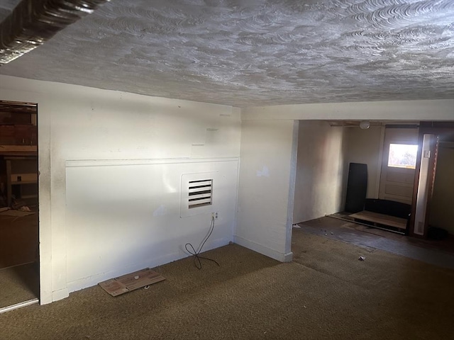 carpeted spare room featuring a textured ceiling