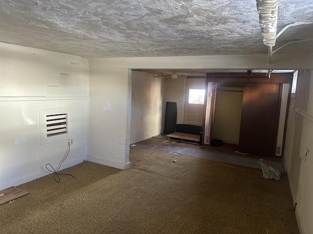 carpeted empty room with a textured ceiling