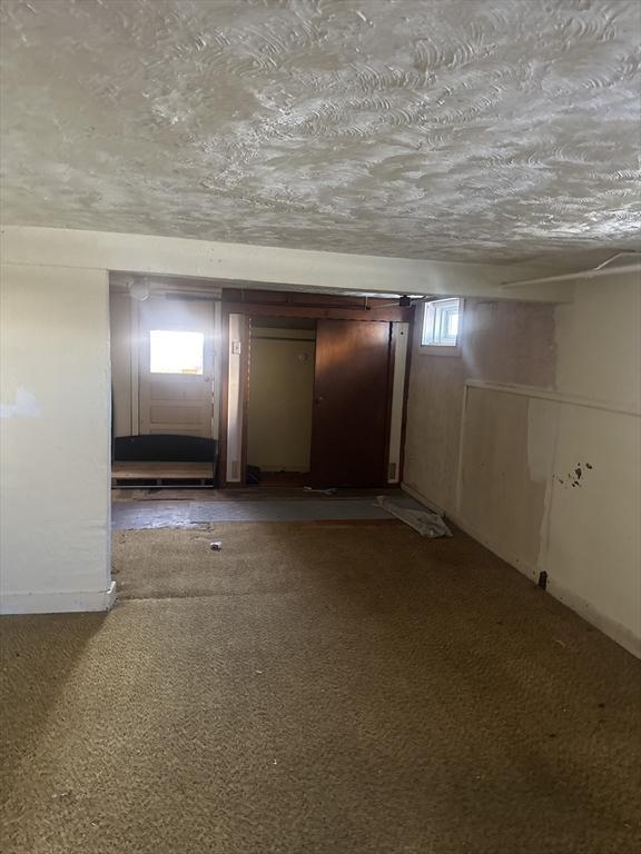 interior space featuring light colored carpet and a textured ceiling