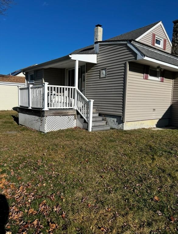 rear view of house featuring a yard