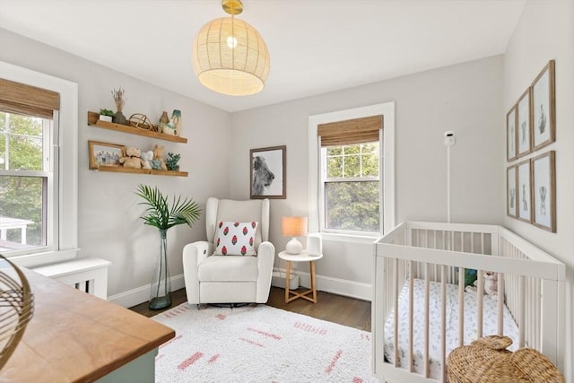 61 Howitt Rd, Boston, MA 02132 - bedroom featuring baseboards, wood finished floors, and a nursery area