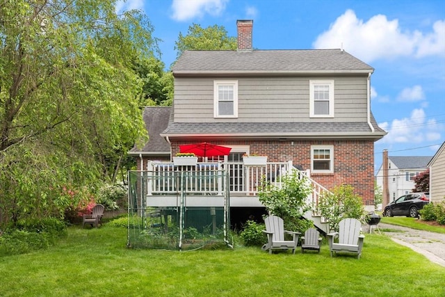 61 Howitt Rd, Boston, MA 02132 - rear view of house with brick siding, a lawn, a chimney, and a wooden deck