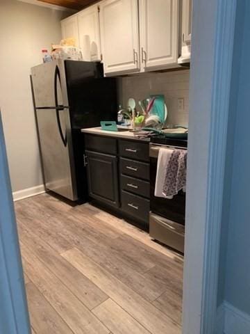 342 Commonwealth Ave Unit 2, Boston, MA 02115 - kitchen with stainless steel appliances, white cabinetry, light wood-style floors, decorative backsplash, and baseboards