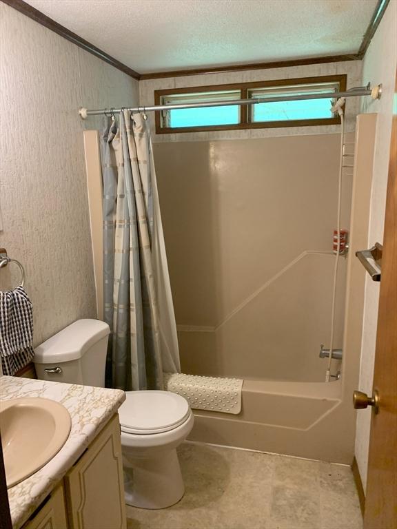 389 Breakneck Rd, Southbridge, MA 01550 - full bath featuring healthy amount of natural light, vanity, shower / bath combo with shower curtain, crown molding, and a textured ceiling
