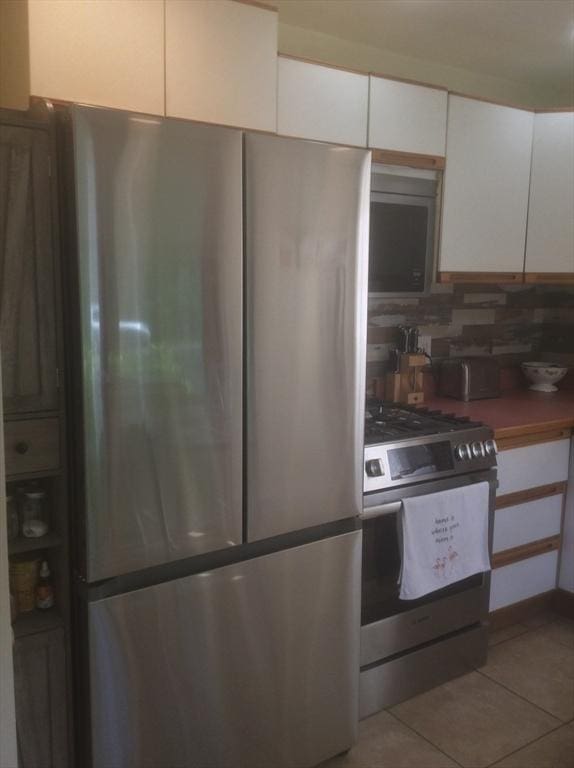 22 Smith St, Norton, MA 02766 - kitchen featuring appliances with stainless steel finishes, white cabinets, light tile patterned floors, and backsplash