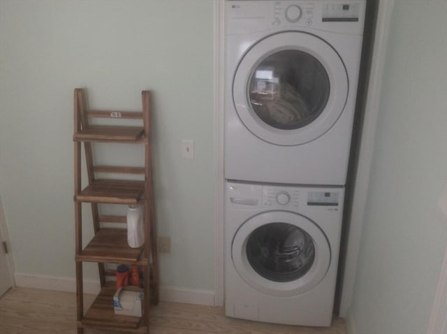 22 Smith St, Norton, MA 02766 - laundry area with stacked washer / drying machine, baseboards, and light wood-style floors