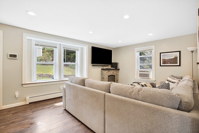 living room featuring a fireplace, a baseboard radiator, hardwood / wood-style floors, and cooling unit