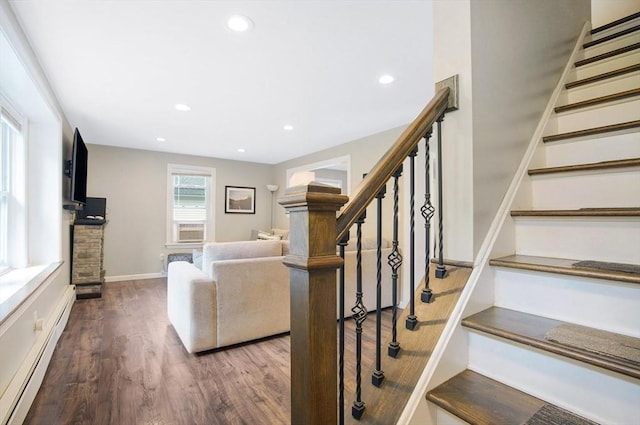 unfurnished living room with a baseboard heating unit, dark hardwood / wood-style flooring, and cooling unit