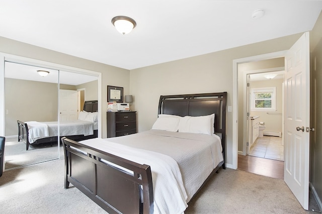 bedroom with light carpet, a closet, and ensuite bathroom