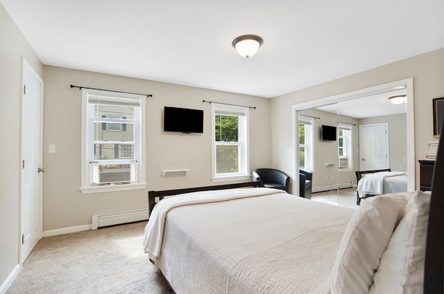 carpeted bedroom featuring a closet and baseboard heating