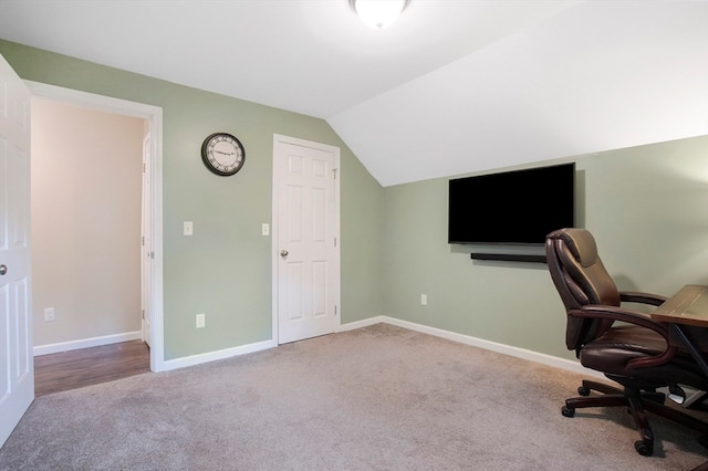 unfurnished office featuring carpet and vaulted ceiling