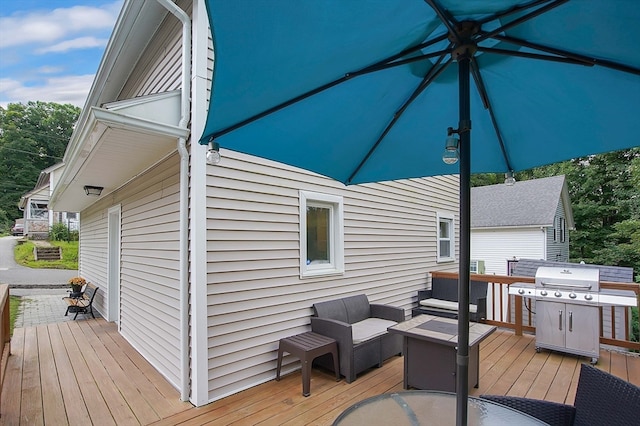 wooden terrace featuring grilling area and an outdoor living space