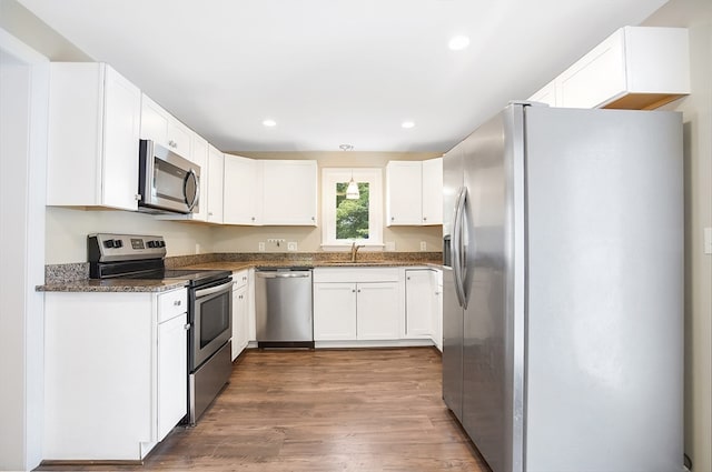 kitchen featuring appliances with stainless steel finishes, dark wood-type flooring, and white cabinetry